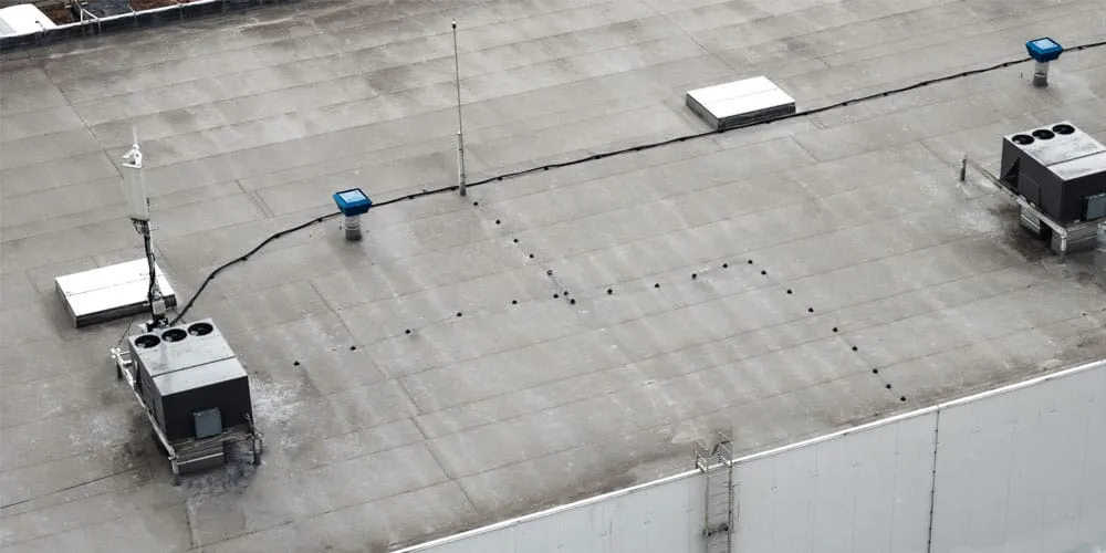 Flat commercial roof featuring rooftop HVAC units, demonstrating durable installation by Roof Dudes Midwest. Specializing in commercial roofing services including storm damage repair, roof replacement, and maintenance.