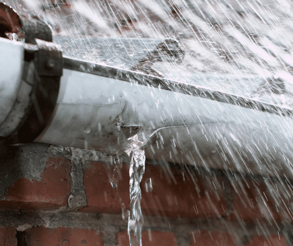 A leaky gutter spilling water during heavy rain, showing the importance of getting gutter repair services in Cincinnati to avoid potential water damage.